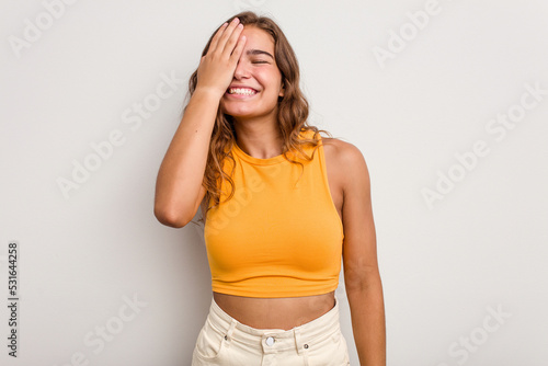 Photos Young caucasian woman isolated on blue background having fun covering half of face with palm
