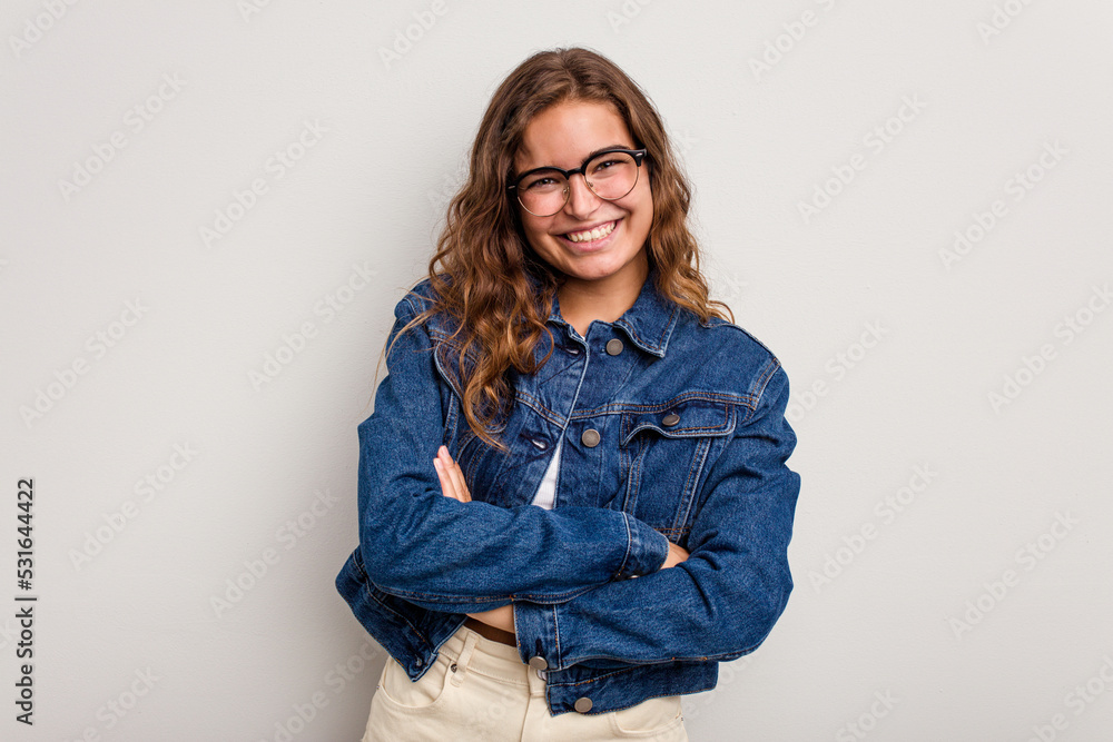 Young caucasian woman isolated on blue background who feels confident, crossing arms with determination. Young caucasian woman isolated on blue background who feels confident, crossing arms with determination.