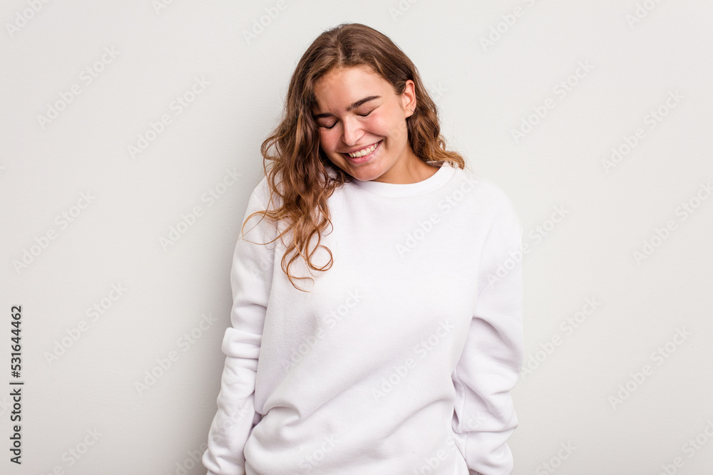 Young caucasian woman isolated on blue background laughs and closes eyes, feels relaxed and happy. Young caucasian woman isolated on blue background laughs and closes eyes, feels relaxed and happy.