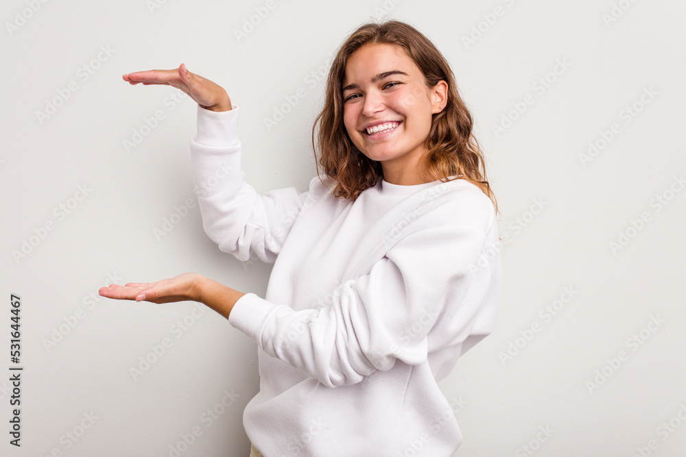 Young caucasian woman isolated on blue background holding something little with forefingers, smiling and confident. Young caucasian woman isolated on blue background holding something little with forefingers, smiling and confident.