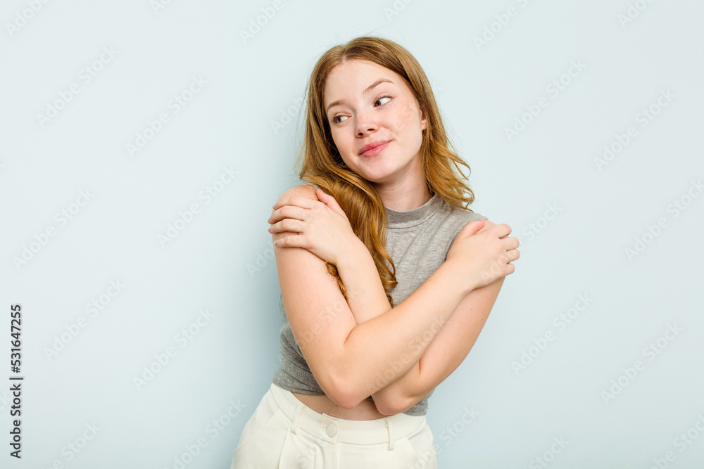 Young caucasian woman isolated on blue background hugs, smiling carefree and happy. Young caucasian woman isolated on blue background hugs, smiling carefree and happy.