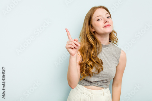 Young caucasian woman isolated on blue background showing number one with finger.