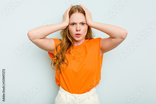 Young caucasian woman isolated on blue background being shocked, she has remembered important meeting.