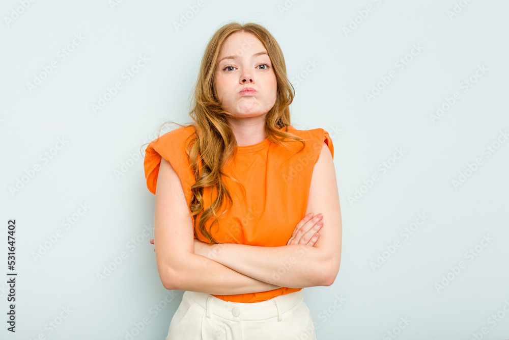 Young caucasian woman isolated on blue background blows cheeks, has tired expression. Facial expression concept. Young caucasian woman isolated on blue background blows cheeks, has tired expression. Facial expression concept.
