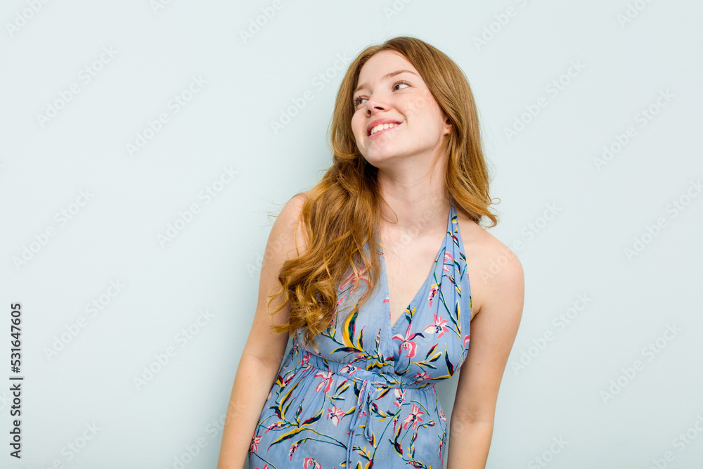 Young caucasian woman isolated on blue background relaxed and happy laughing, neck stretched showing teeth. Young caucasian woman isolated on blue background relaxed and happy laughing, neck stretched showing teeth.