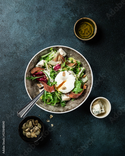 lunch bowl of spinach salad with bacon, mushrooms, eggs and red onions on gray background