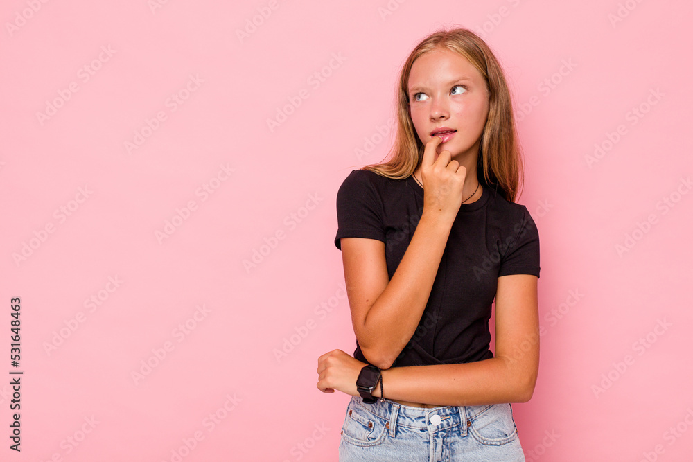 Caucasian teen girl isolated on pink background looking sideways with doubtful and skeptical expression. Caucasian teen girl isolated on pink background looking sideways with doubtful and skeptical expression.
