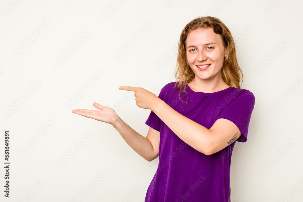 Young caucasian woman isolated on white background excited holding a copy space on palm. Young caucasian woman isolated on white background excited holding a copy space on palm.