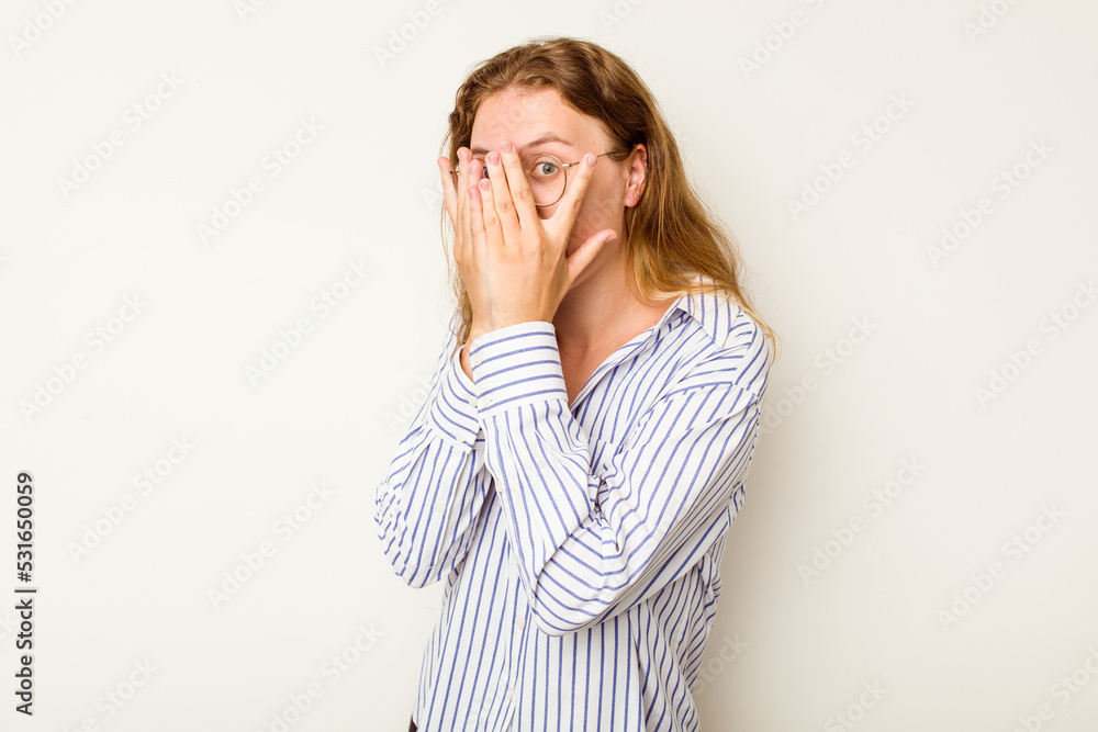 Young caucasian woman isolated on white background blink through fingers frightened and nervous. Young caucasian woman isolated on white background blink through fingers frightened and nervous.