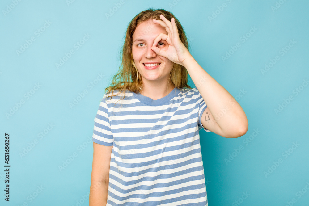 Young caucasian woman isolated on blue background excited keeping ok gesture on eye. Young caucasian woman isolated on blue background excited keeping ok gesture on eye.
