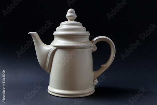 White porcelain teapot on a black background.