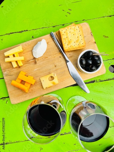 One with wine and cheese. Different types of cheese complimenting your red wine. Cheese platter. Wooden board.