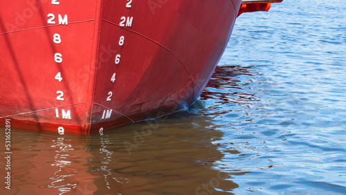Bild auf Leinwand Draft mark numbers on red steel hull surface of nautical vessel while docked at