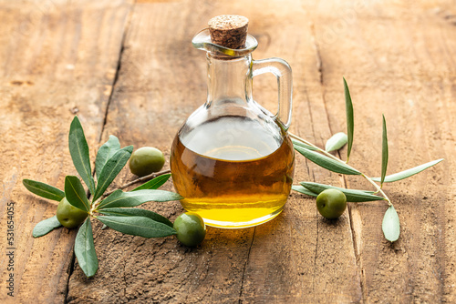 green olives with olive oil. extra virgin olive oil jars on a wooden background. place for text