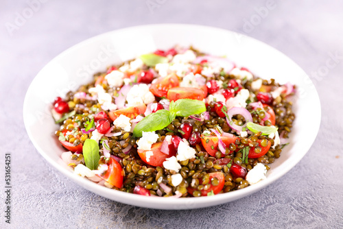 bowl of lentils salad with feta, tomato and pomegranate