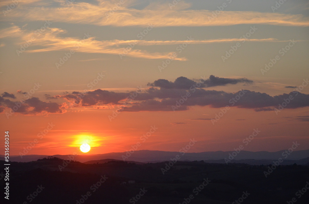 Sunset falling over the beautiful countryside and town of Montepulciano in Tuscany on a bright summer day