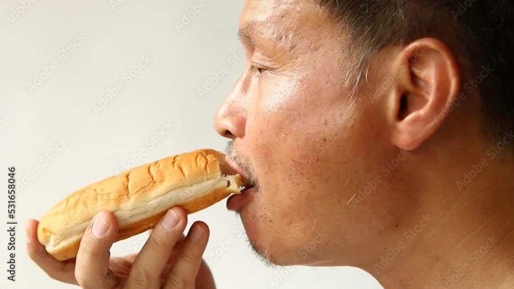 Thai man is eating bread , in door Chiangmai Thailand Thai man is eating bread , in door Chiangmai Thailand
