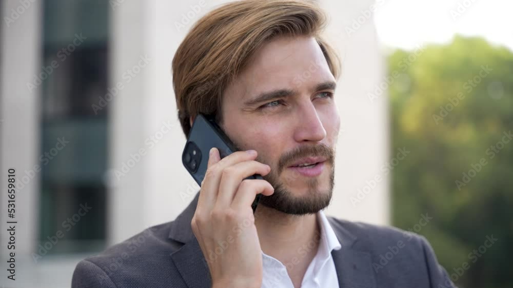 Portrait handsome man having phone talk outdoor. Business man talking on smartphone at street Portrait handsome man having phone talk outdoor. Business man talking on smartphone at street