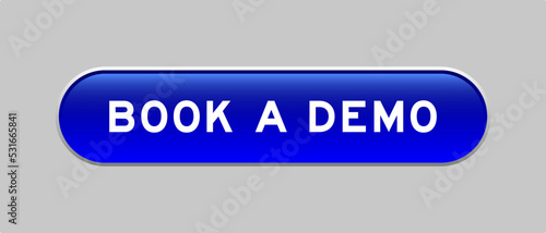 Blue color capsule shape button with word book a demo on gray background