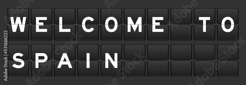 Black color analog flip board with word welcome to spain on gray background