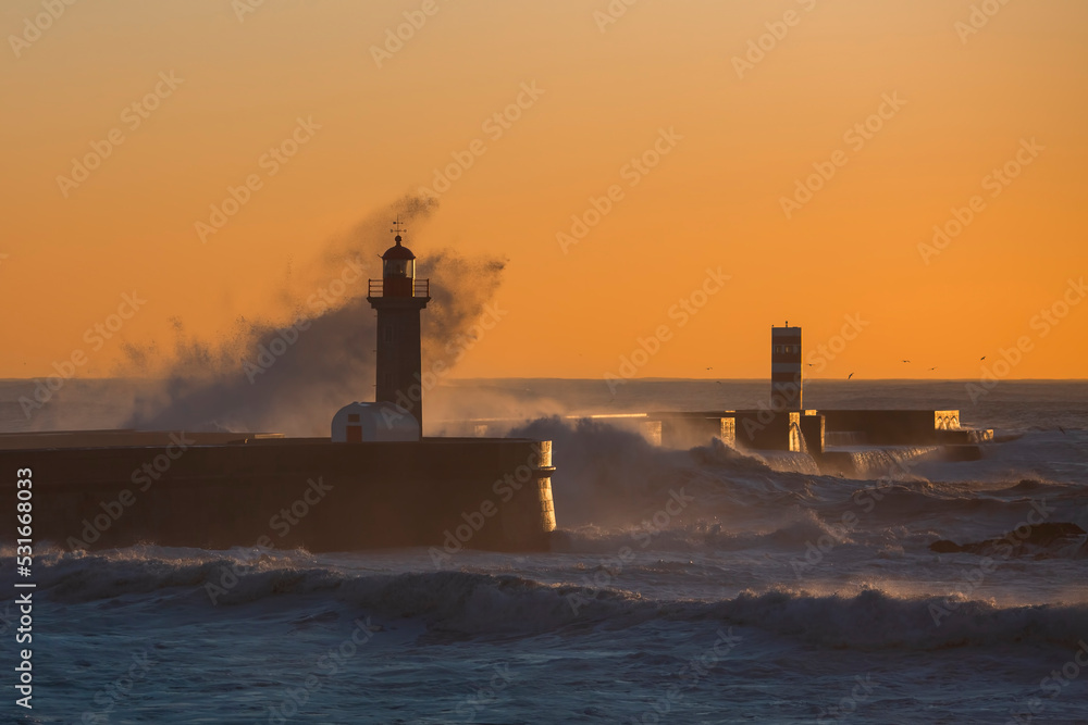 View of a lighthouse, washed in the twilight by a wave. Porto, Portugal.