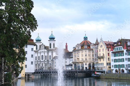 LUCERNE, Switzerland - December 2020: through the spray of the fountain, a beautiful view of the autumn, winter city of Lucerne is visible, residents and tourists walk along streets, bridge
