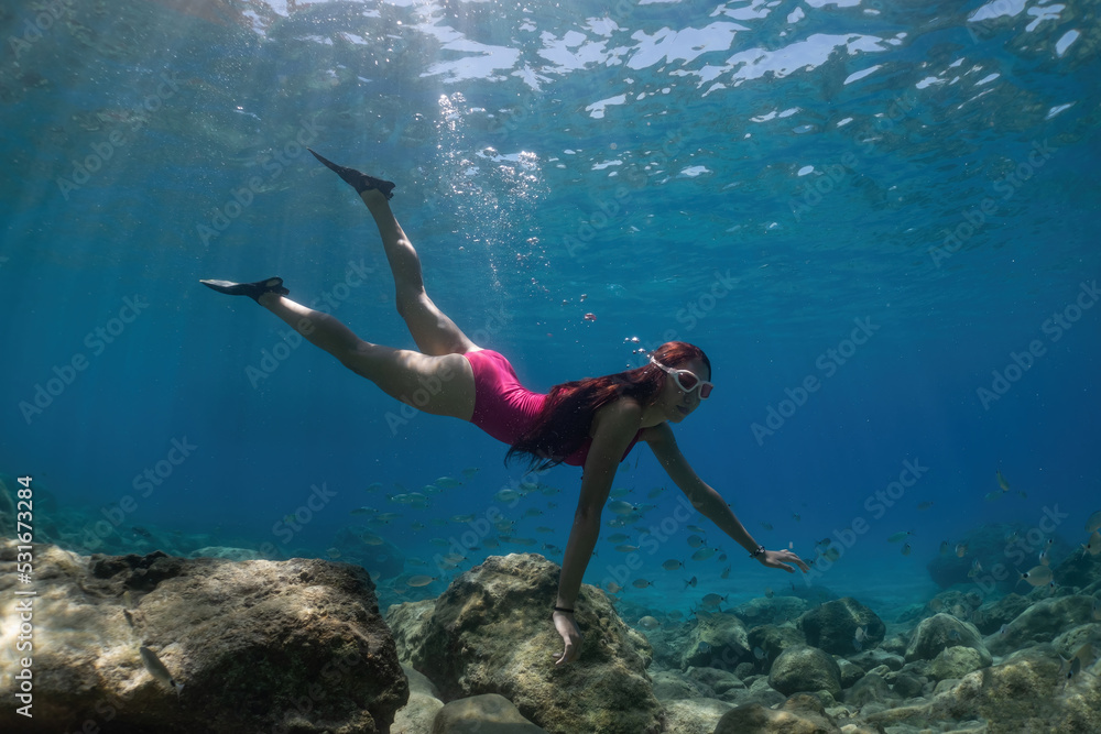 Freediver woman underwater in the sea. Underwater shooting.