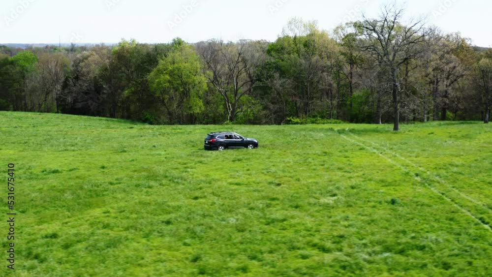 Land Surveyors In A Black SUV Car Driving On The Farm At Daytime. aerial drone Land Surveyors In A Black SUV Car Driving On The Farm At Daytime. aerial drone