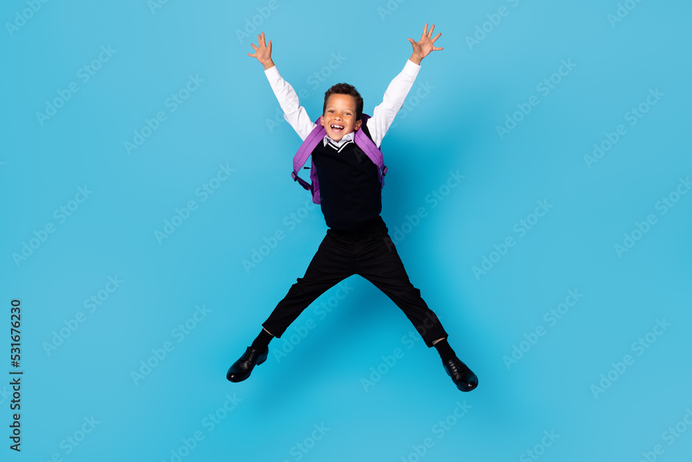 Full body portrait of overjoyed carefree boy jumping raise hands make star figure isolated on blue color background