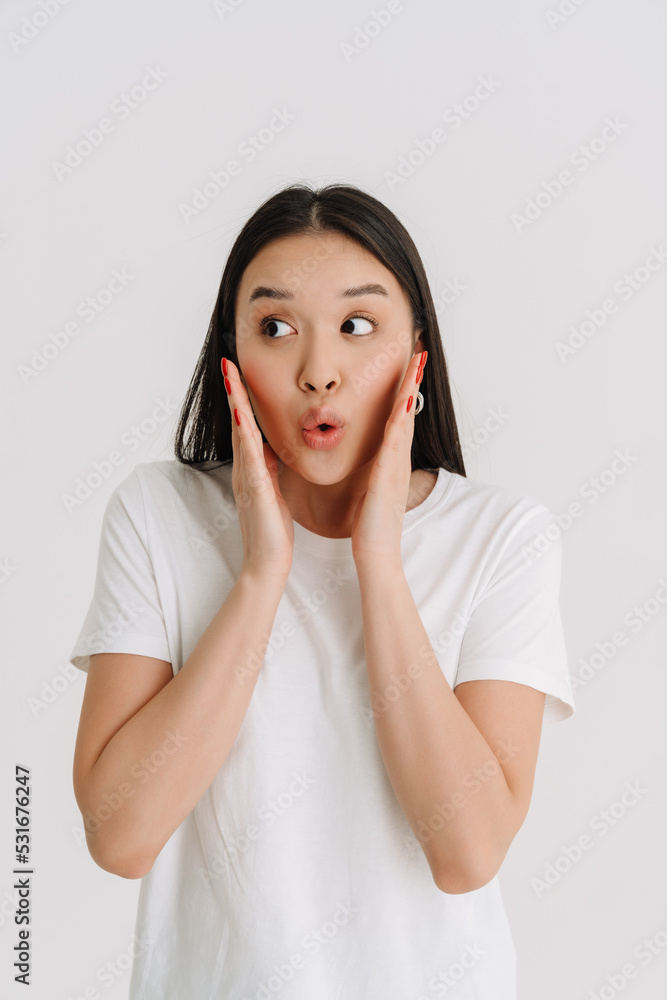 Asian young woman wearing t-shirt expressing surprise at camera Asian young woman wearing t-shirt expressing surprise at camera