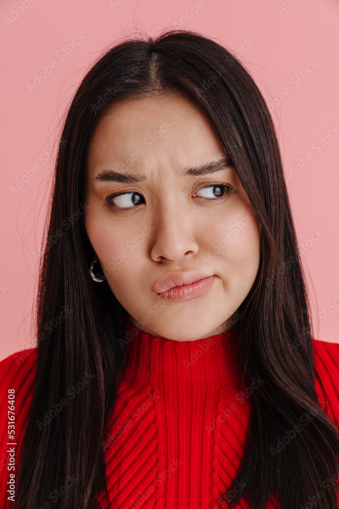 Asian displeased woman frowning and looking aside Asian displeased woman frowning and looking aside
