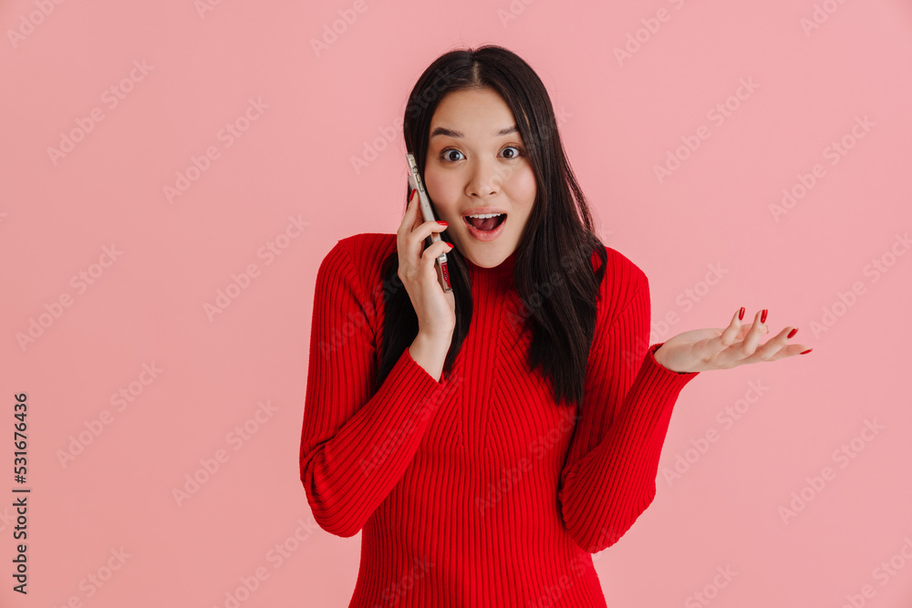 Asian young woman holding copyspace while talking on mobile phone Asian young woman holding copyspace while talking on mobile phone