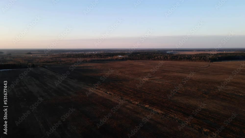 hang glider flying on the field at sunset, shooting from a drone hang glider flying on the field at sunset, shooting from a drone