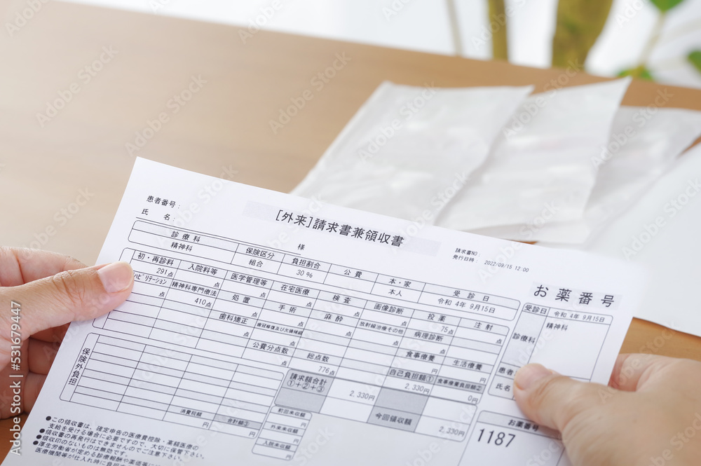 Obraz premium 医療費の請求書を見つめる女性