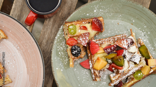 Belgian waffles with fruits on the table, top view