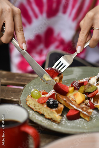 Girl eating Belgian waffle in a restaurant