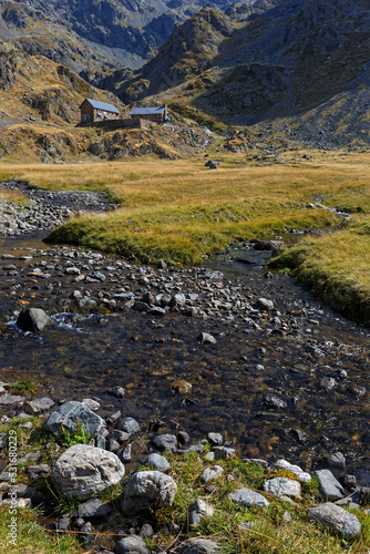 Creek on La Pra plateau and mountain hut in the background