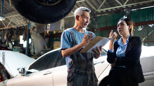 Asian young woman customer talking with owner and mechanic worker at car repair service and auto store shop.