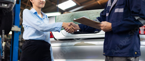 female customer shakes hands with a service claim employee at car repair service and auto store shop.