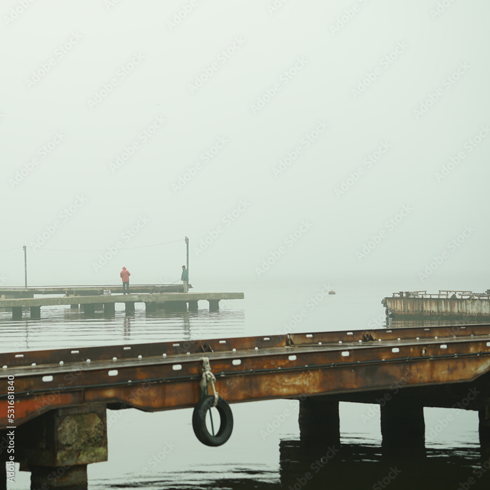 Obraz premium foggy dock. pier, autumn silence. calm. fishermen.