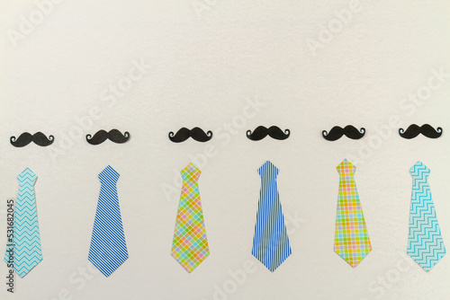 Mens neckties and moustaches on white surface. Fathers day concept.