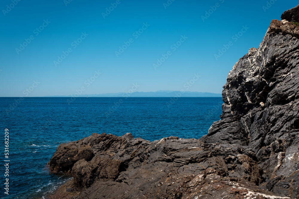 Rocky outcropping and deep blue sea off the coast of the Italian city of Camoglia on the Ligurian Sea. Rocky outcropping and deep blue sea off the coast of the Italian city of Camoglia on the Ligurian Sea.