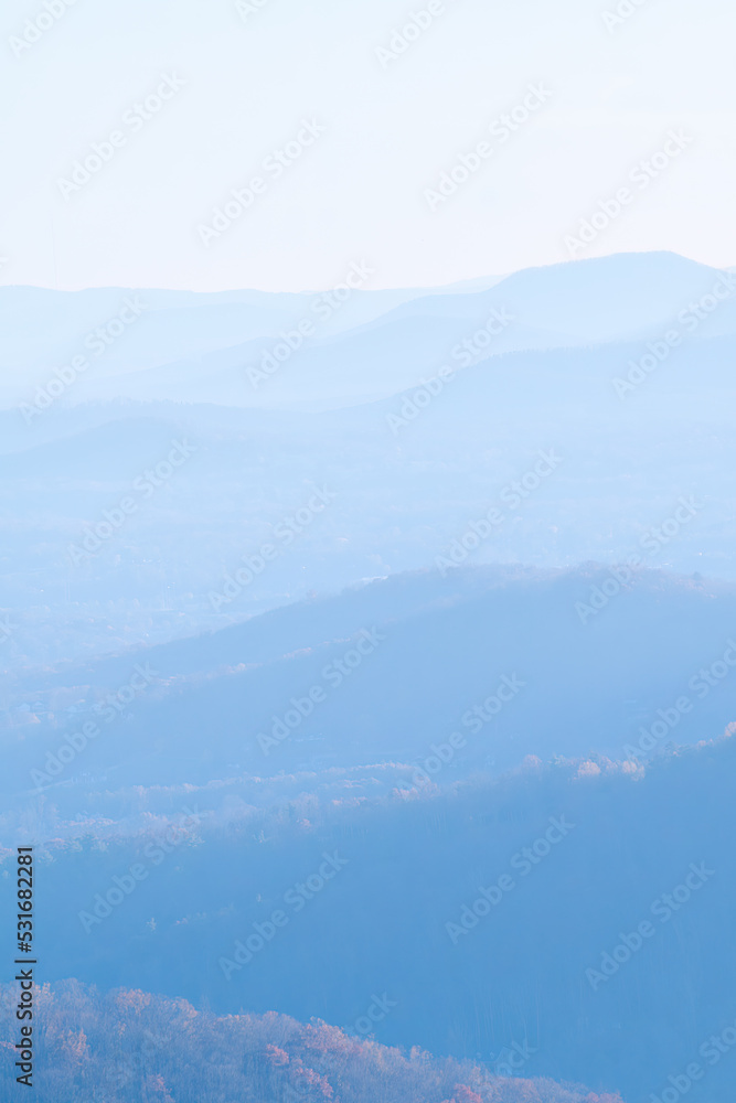 Forest covered hills in the mountains of North Carolina with much mist and partially hidden layers.