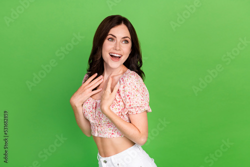 Photo of good mood gorgeous girl wavy hairdo dressed colored blouse hands chest look empty space isolated on green color background
