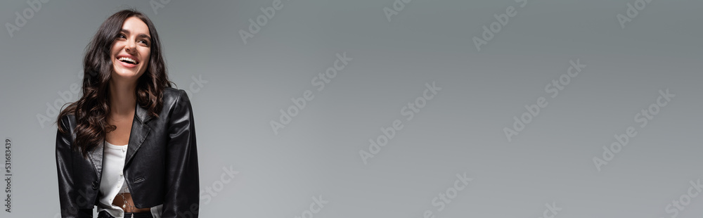 happy young woman in stylish black leather jacket isolated on grey, banner. happy young woman in stylish black leather jacket isolated on grey, banner.