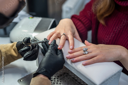 beautician doing manicure female customer in nail salon