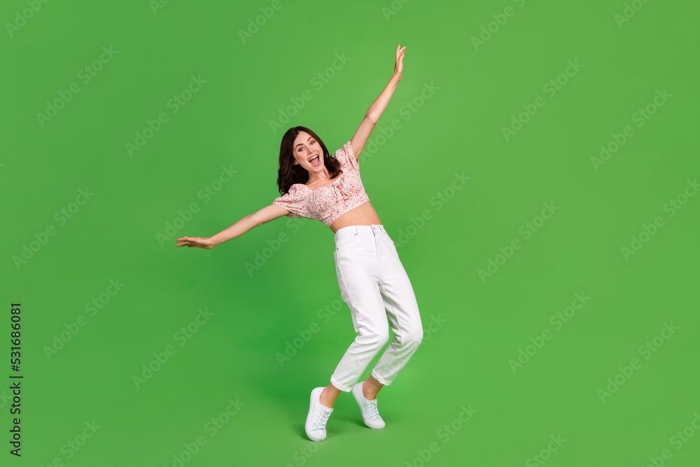 Full size photo of careless pretty girl with curly hairdo wear white pants top falling in deep isolated on green color background Full size photo of careless pretty girl with curly hairdo wear white pants top falling in deep isolated on green color background