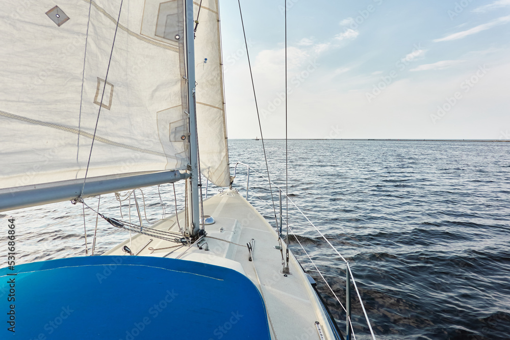 White sloop rigged yacht sailing in the Baltic sea after the storm. Waves, splashes, water surface. Cruise, summer vacations, regatta, sport, leisure activity, tourism, wanderlust concepts White sloop rigged yacht sailing in the Baltic sea after the storm. Waves, splashes, water surface. Cruise, summer vacations, regatta, sport, leisure activity, tourism, wanderlust concepts