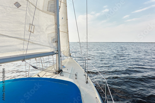 White sloop rigged yacht sailing in the Baltic sea after the storm. Waves, splashes, water surface. Cruise, summer vacations, regatta, sport, leisure activity, tourism, wanderlust concepts