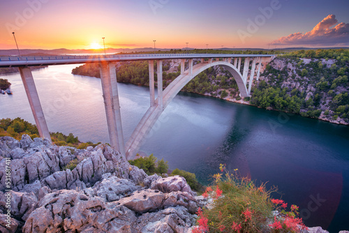 Obraz na płótnie Krka Bridge, Croatia. Image of concrete arch bridge Krka Bridge spanning the Krka River at sunset. w salonie